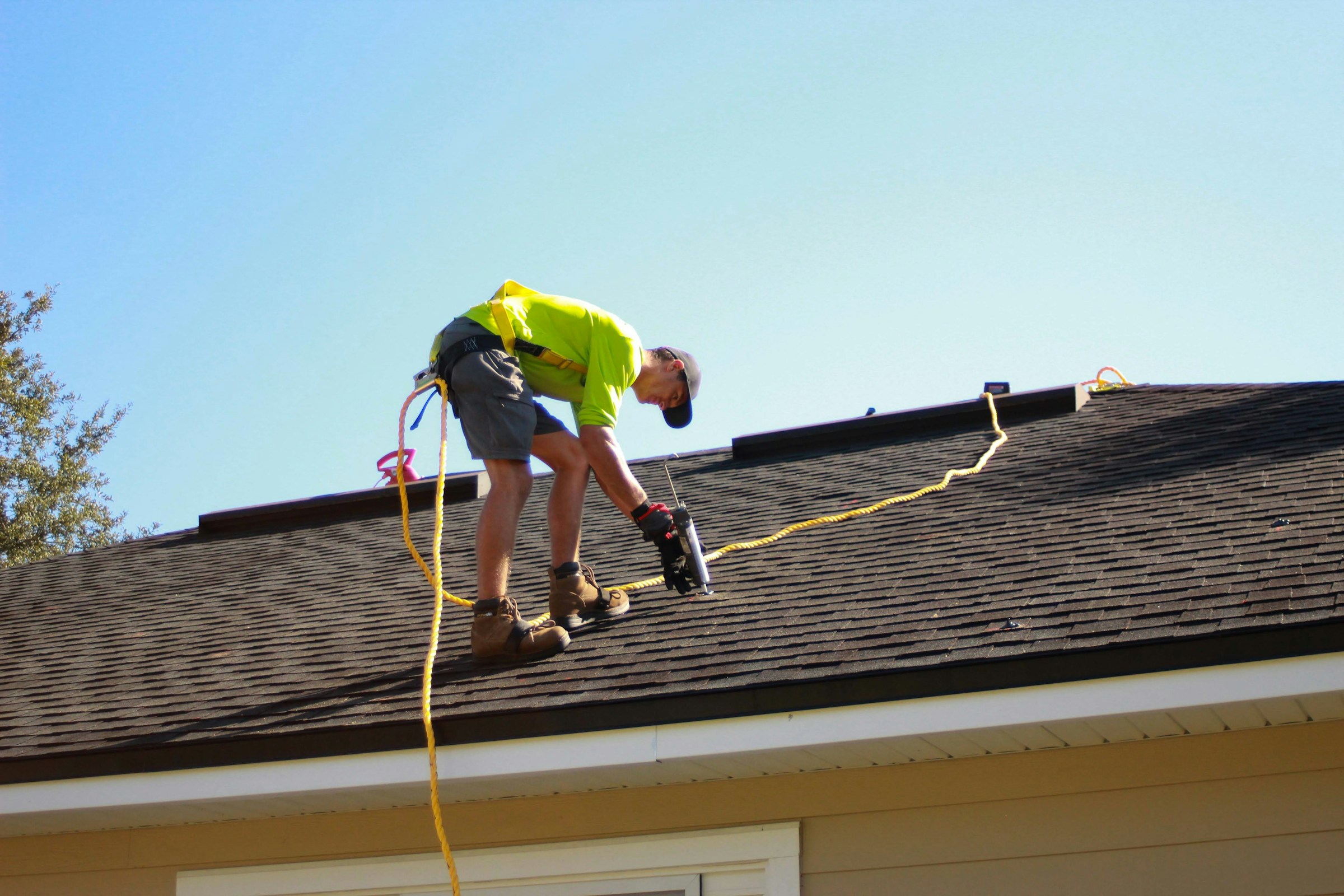A roofer and a homeowner shaking hands in front of a house